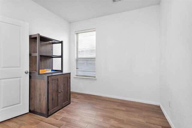 interior space with visible vents, baseboards, and wood finished floors