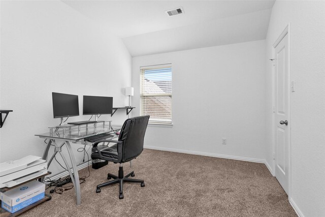 carpeted office with visible vents, baseboards, and vaulted ceiling