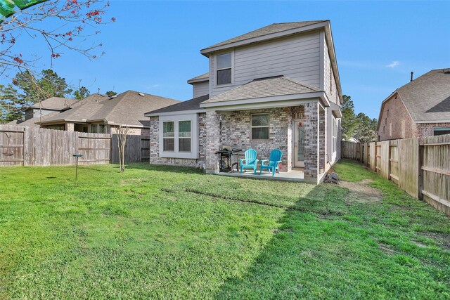 back of property with a patio area, a fenced backyard, a yard, and roof with shingles