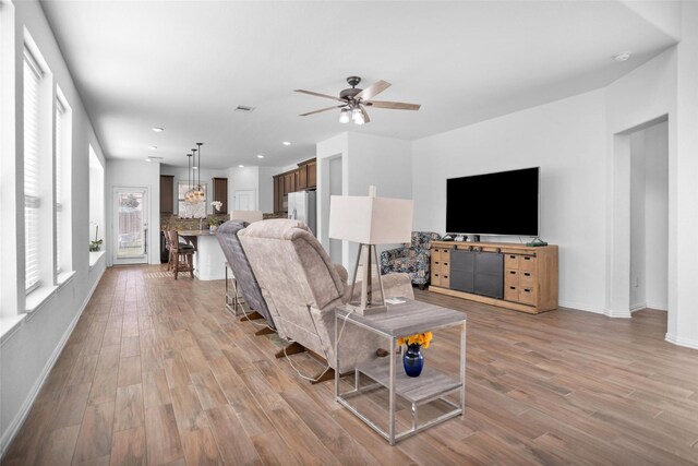 living room featuring a ceiling fan, recessed lighting, light wood-style floors, and baseboards