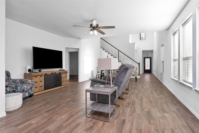 living room featuring stairs, wood finished floors, and a ceiling fan