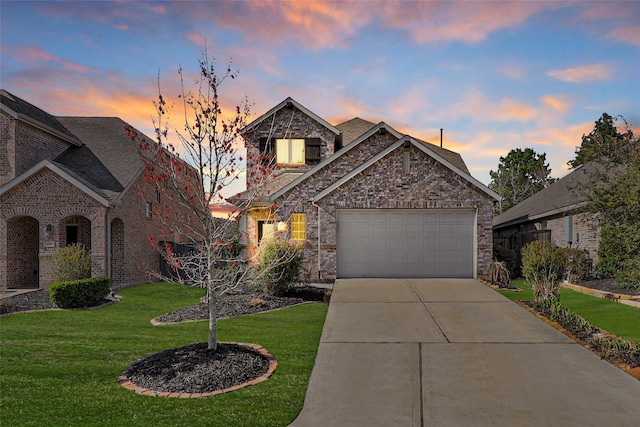 view of front of home with a yard, an attached garage, concrete driveway, stone siding, and brick siding