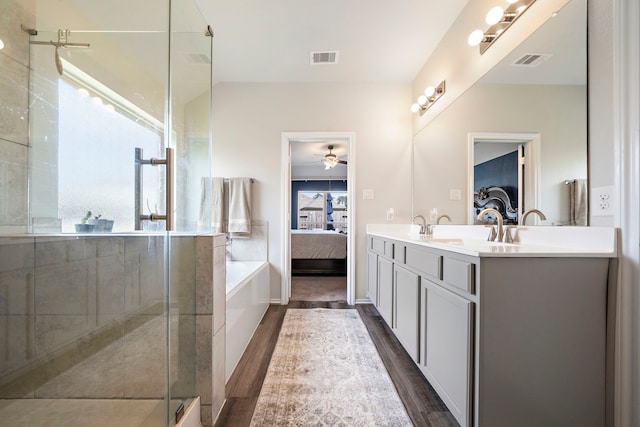 ensuite bathroom with visible vents, connected bathroom, a shower stall, and double vanity