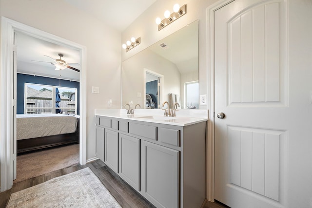 ensuite bathroom featuring a ceiling fan, ensuite bathroom, a sink, wood finished floors, and double vanity