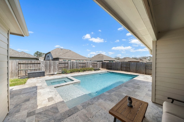 view of pool with a fenced backyard, a pool with connected hot tub, and a patio