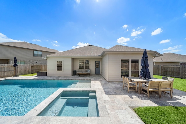 view of pool featuring a fenced backyard, a pool with connected hot tub, and a patio