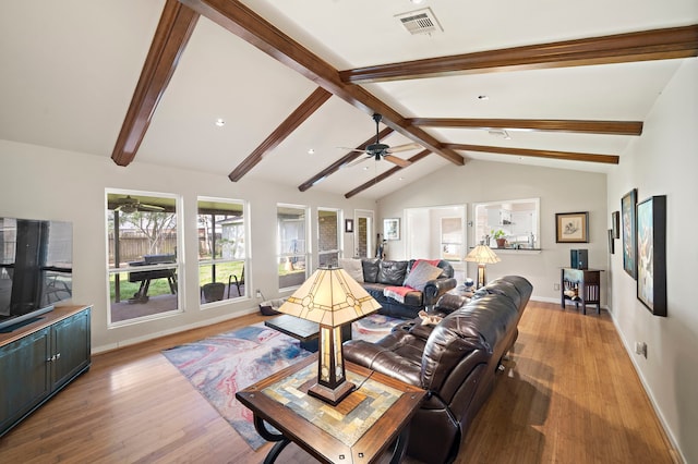 living area featuring lofted ceiling with beams, visible vents, light wood-type flooring, and ceiling fan