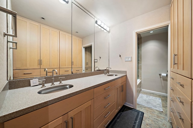 bathroom with a sink, baseboards, and double vanity