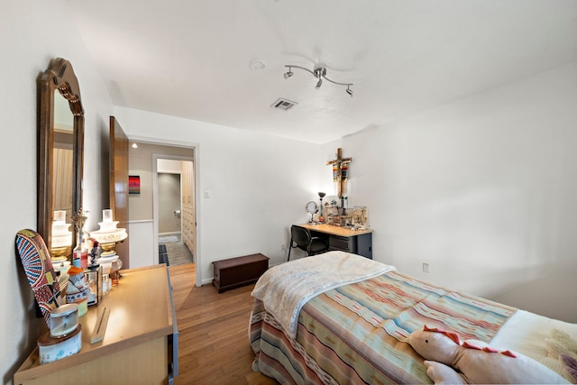 bedroom with visible vents and wood finished floors