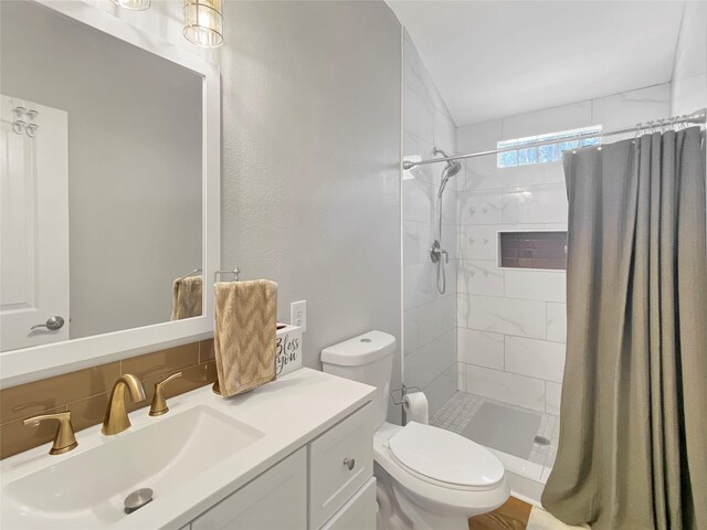 bathroom with vanity, tasteful backsplash, a shower stall, and toilet