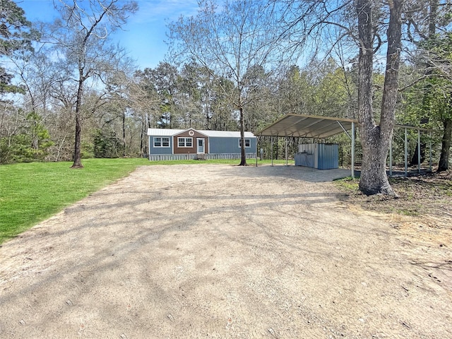 manufactured / mobile home featuring a front lawn and dirt driveway