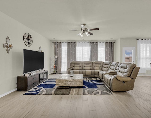 living area with a wealth of natural light, ceiling fan, and wood finished floors