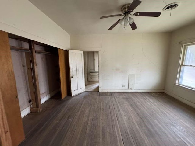 unfurnished bedroom with dark wood finished floors, visible vents, baseboards, and a closet