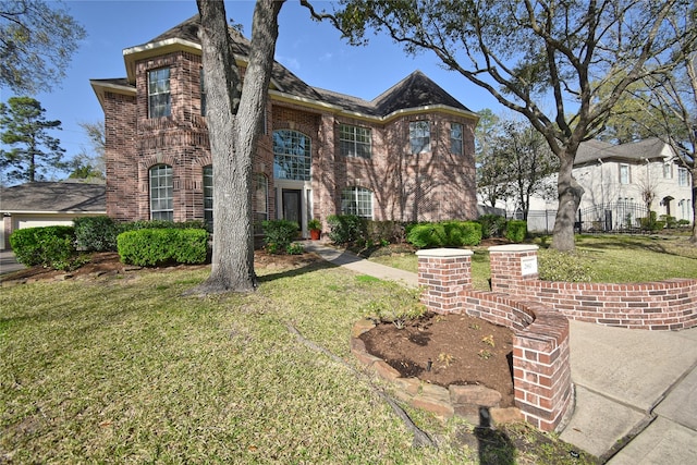 view of front of home featuring a front lawn, fence, and brick siding