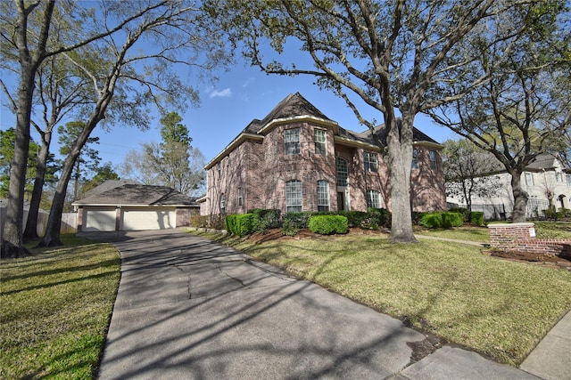 view of front of property featuring an outbuilding, driveway, a front lawn, fence, and brick siding