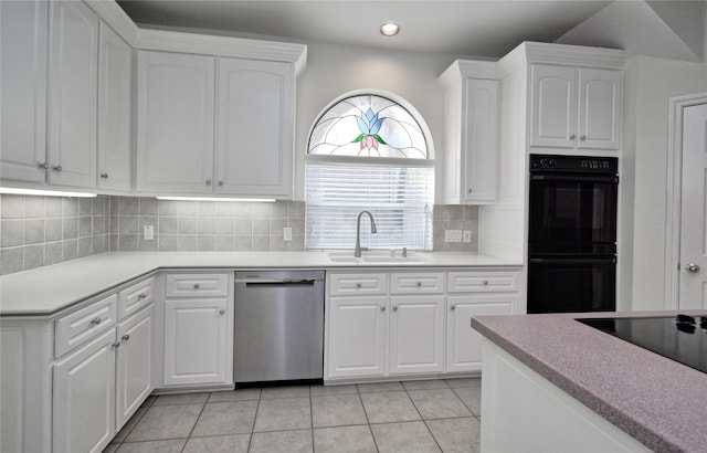 kitchen featuring backsplash, dishwasher, light tile patterned flooring, dobule oven black, and a sink