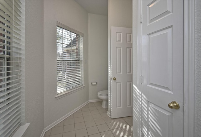 bathroom with tile patterned flooring, toilet, and baseboards