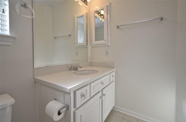 bathroom with vanity, toilet, baseboards, and tile patterned flooring