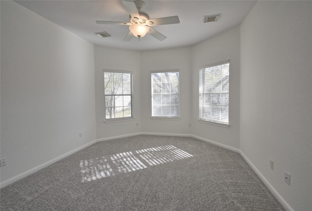 carpeted spare room featuring visible vents, baseboards, and a ceiling fan