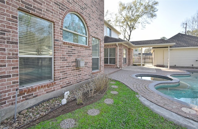 view of swimming pool with a patio area, fence, and a pool with connected hot tub