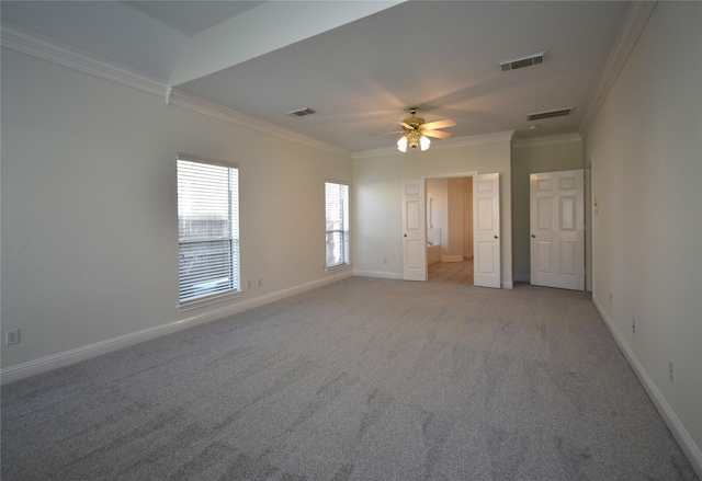 carpeted spare room featuring visible vents, baseboards, ceiling fan, and crown molding