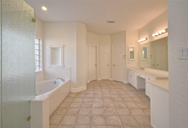 full bathroom featuring visible vents, baseboards, a garden tub, and vanity