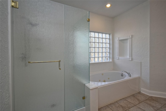 bathroom with tile patterned floors, a shower stall, baseboards, a whirlpool tub, and a textured wall