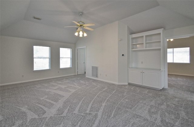 carpeted empty room featuring visible vents, ceiling fan, baseboards, and lofted ceiling