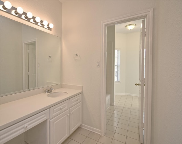 full bath featuring vanity, tile patterned floors, and baseboards