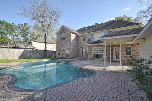 view of pool featuring a patio area, a pool with connected hot tub, and a fenced backyard