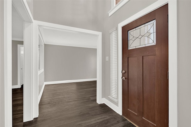 foyer featuring baseboards and dark wood-style floors