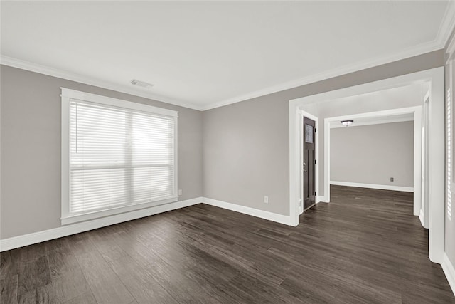 empty room with dark wood-type flooring, crown molding, visible vents, and baseboards