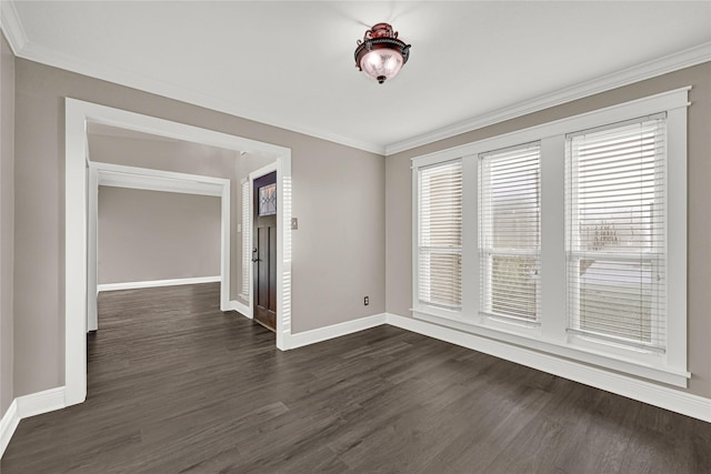 empty room featuring dark wood-style floors, baseboards, and ornamental molding