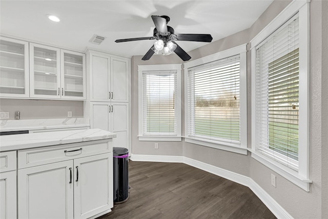 kitchen featuring baseboards, visible vents, dark wood-type flooring, white cabinets, and glass insert cabinets