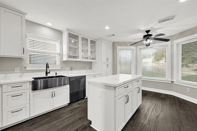 kitchen featuring dark wood finished floors, black dishwasher, visible vents, and a sink