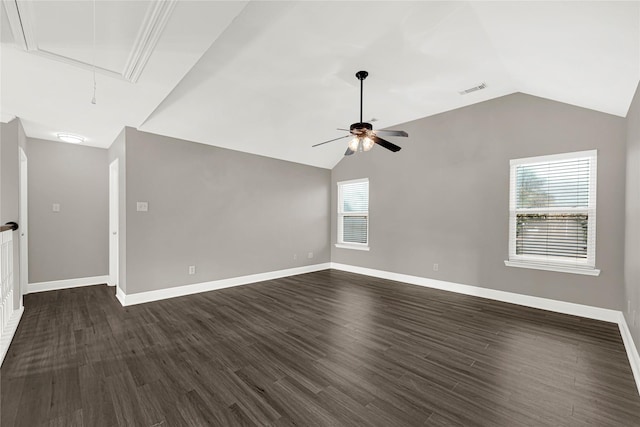 empty room with dark wood-style floors, a ceiling fan, visible vents, attic access, and vaulted ceiling