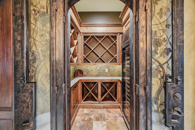 wine area featuring stone finish flooring and arched walkways