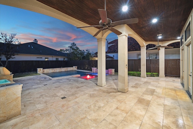 patio terrace at dusk featuring a ceiling fan, a fenced in pool, and a fenced backyard