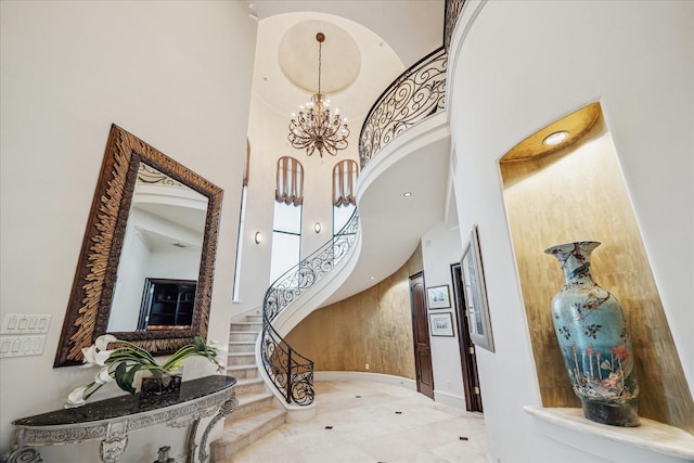 stairway featuring a towering ceiling and a chandelier