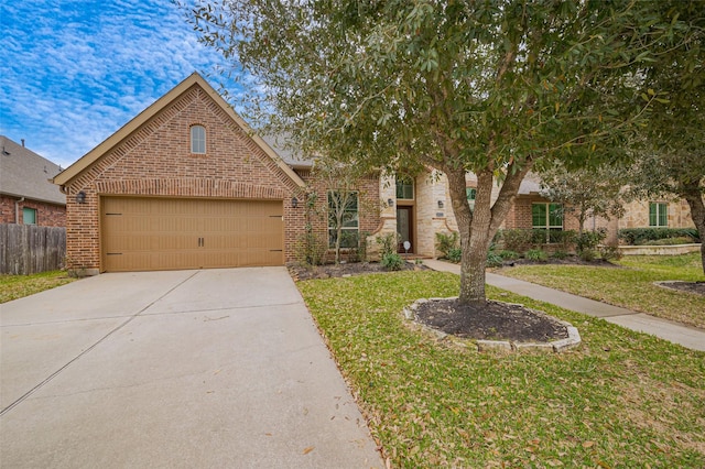 view of front of house featuring a front lawn, driveway, fence, an attached garage, and brick siding