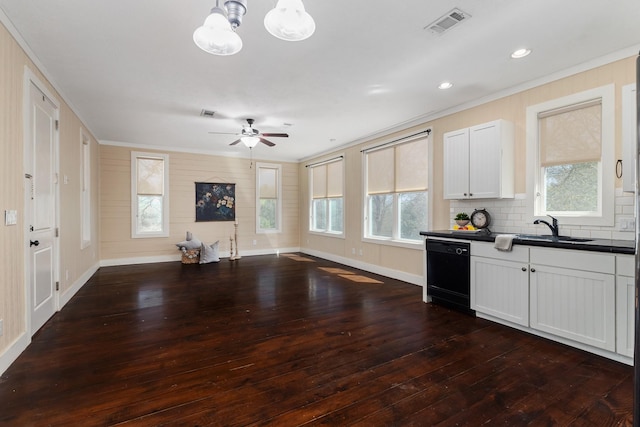 kitchen with a sink, black dishwasher, dark countertops, open floor plan, and dark wood-style flooring