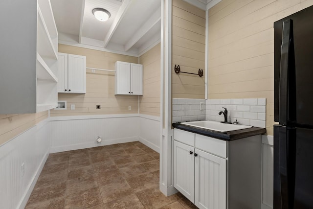 washroom with electric dryer hookup, a sink, cabinet space, wood walls, and hookup for a washing machine