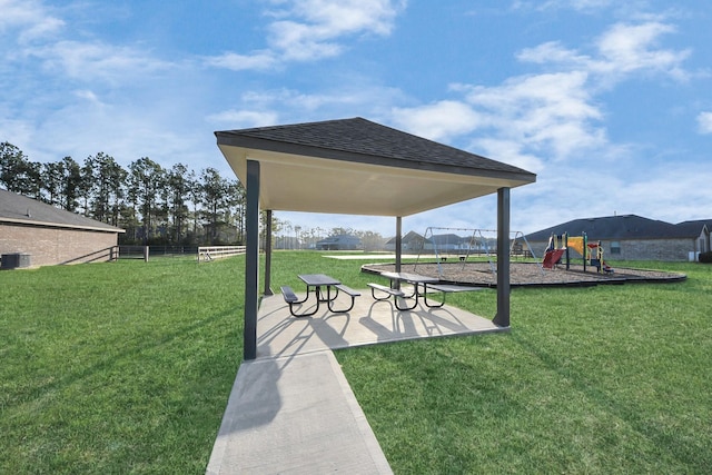 view of property's community with playground community, a lawn, a patio area, and fence