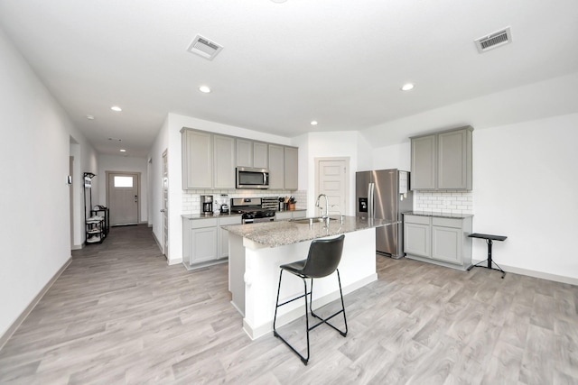 kitchen with visible vents, gray cabinets, appliances with stainless steel finishes, and a sink