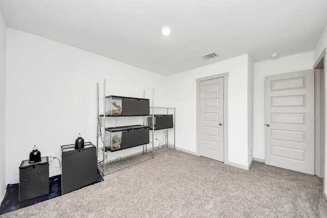 interior space featuring visible vents, baseboards, and carpet