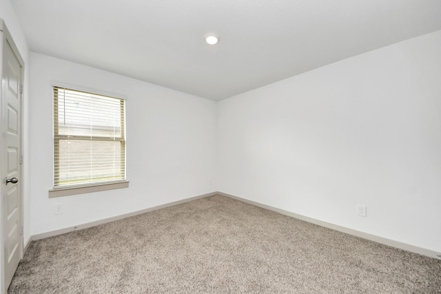 empty room featuring baseboards and carpet flooring