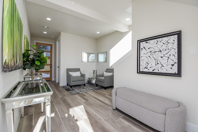 living area with light wood-style flooring, recessed lighting, visible vents, and baseboards