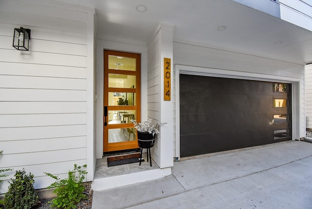 doorway to property with concrete driveway and a garage