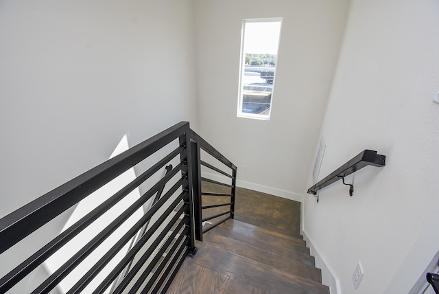 staircase with baseboards and wood finished floors