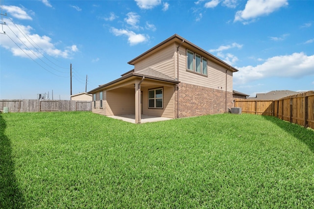 rear view of house featuring a yard, a fenced backyard, and a patio area